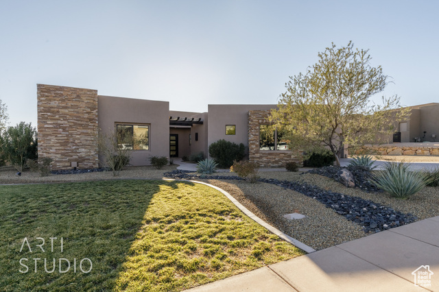 Pueblo revival-style home with a front lawn