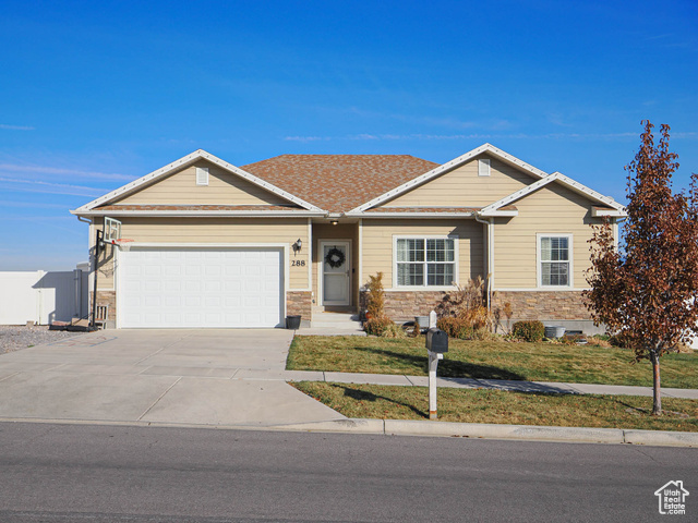 View of front of home with a front lawn and a garage