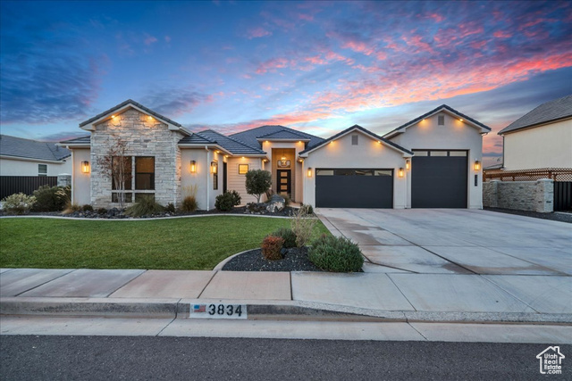 View of front of property featuring a garage and a lawn