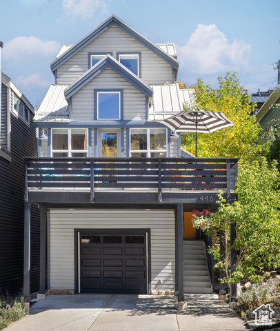 View of front of home featuring a garage and a balcony