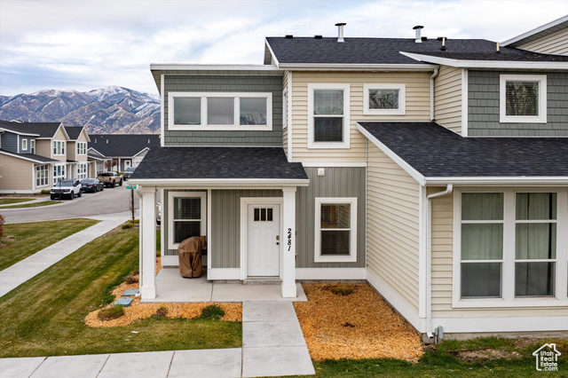 View of front of property featuring a mountain view and a front yard