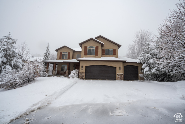 View of property featuring covered porch and a garage