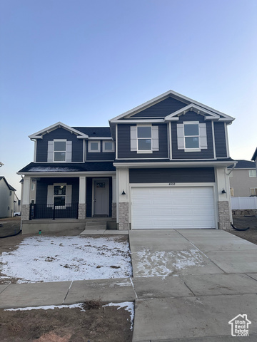 View of front of home with a porch and a garage