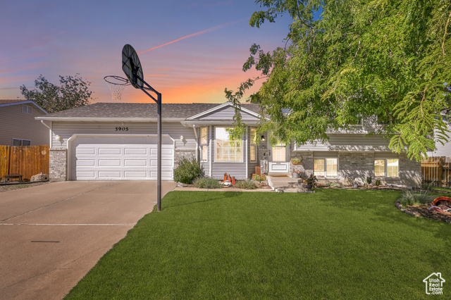 View of front of house featuring a lawn and a garage