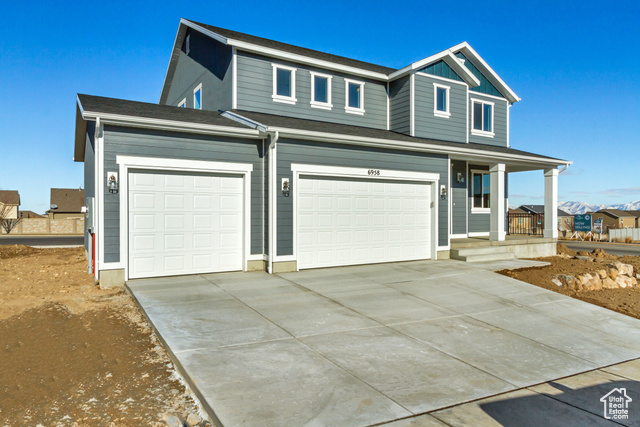 View of front facade with a porch and a garage