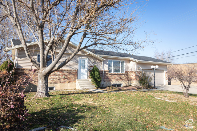 Ranch-style home with a garage and a front lawn