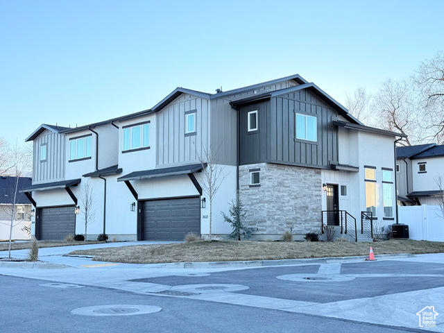 View of front of property featuring cooling unit and a garage