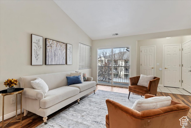 Living room featuring high vaulted ceiling and light hardwood / wood-style floors