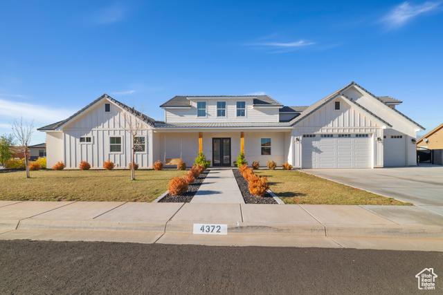 Modern farmhouse with a garage and a front lawn