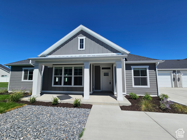 View of front of property with covered porch and a garage