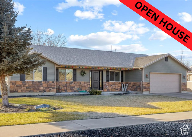 Single story home with a front yard and a garage