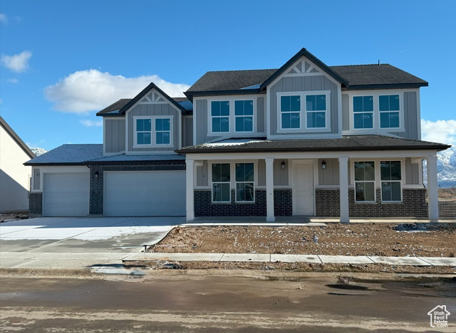 Craftsman-style home featuring covered porch and a garage