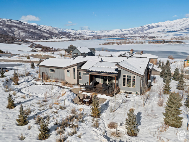 Snow covered property featuring a deck with mountain view