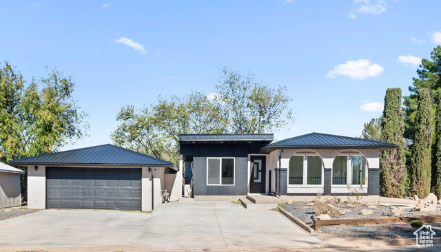 View of front of home with a porch and a garage