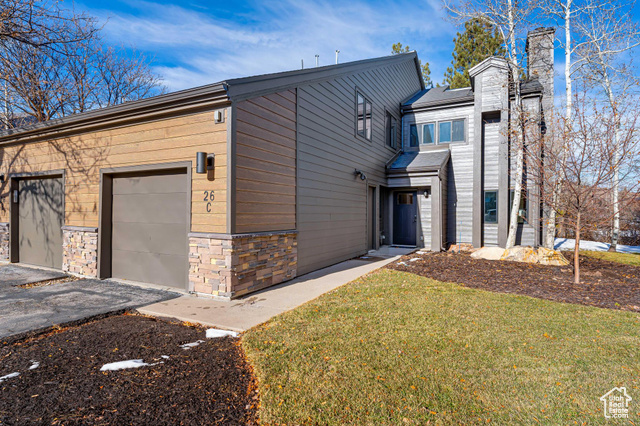 View of front of property featuring a front lawn and a garage