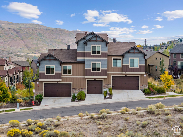 View of front of property with a mountain view and a garage