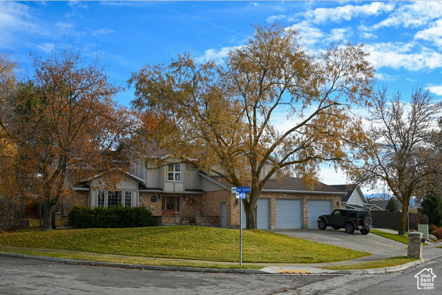 View of front of property with a garage and a front lawn