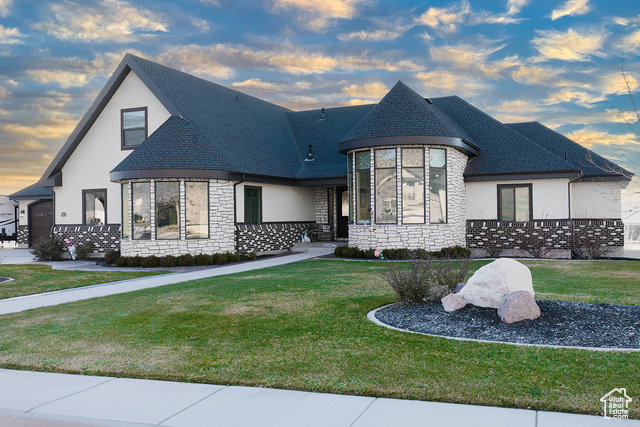 French country inspired facade with a yard