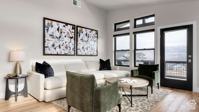 Living room with vaulted ceiling and light hardwood / wood-style flooring