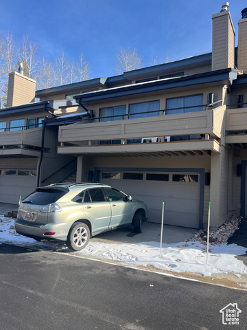 View of front of house featuring a balcony and a garage