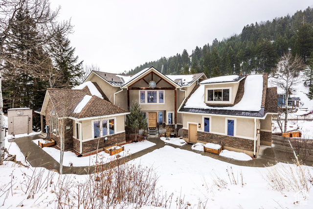 Snow covered rear of property featuring a storage shed