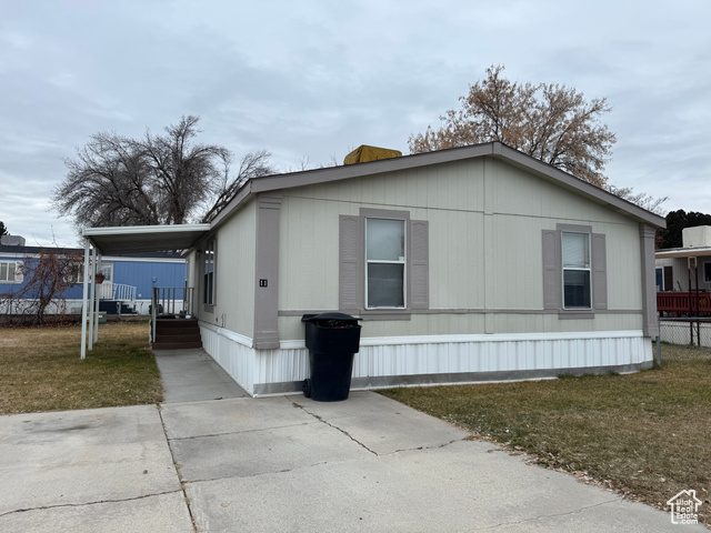 View of side of home featuring a yard and a carport