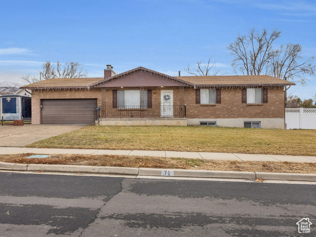 Single story home with a garage and a front lawn