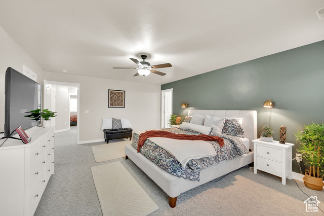 Carpeted bedroom featuring ceiling fan