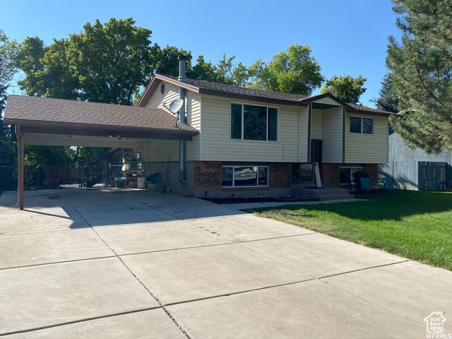 View of front facade featuring a front lawn and a carport