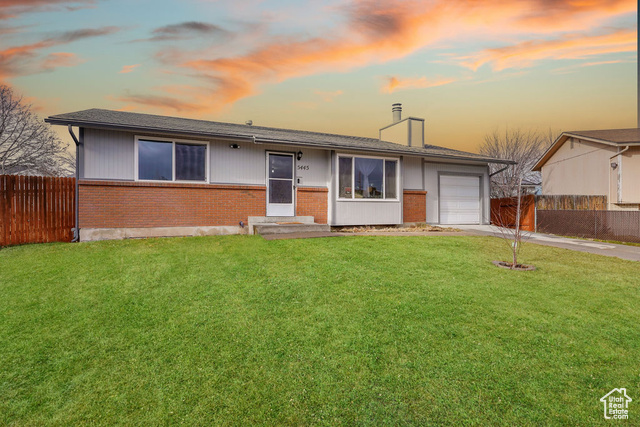 Ranch-style home with a lawn and a garage