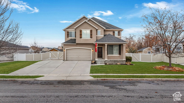 Front facade featuring a front yard and a garage