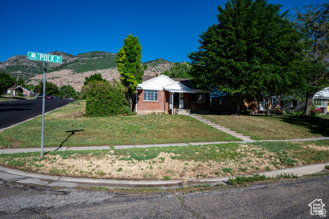 View of front of house featuring a mountain view and a front lawn