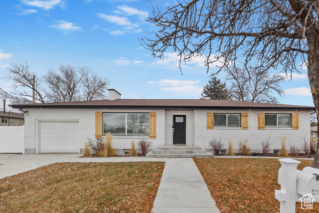 Single story home featuring a front yard and a garage