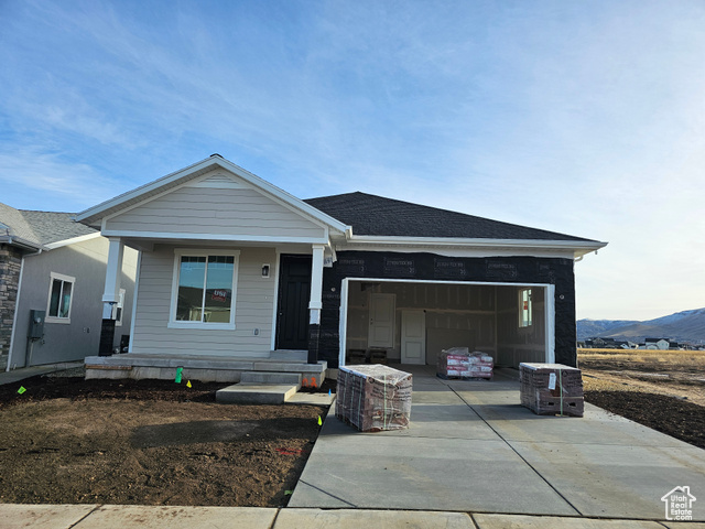 View of front of home featuring brick, a porch, and a garage