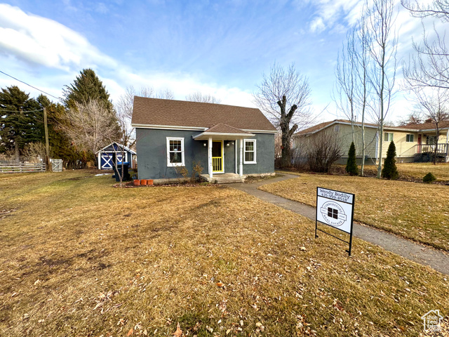 Ranch-style house with a front lawn and a shed