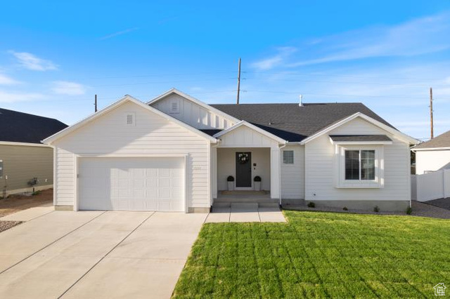 Ranch-style home with a front lawn and a garage