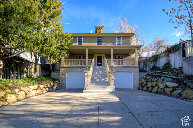 View of front facade featuring covered porch and a garage