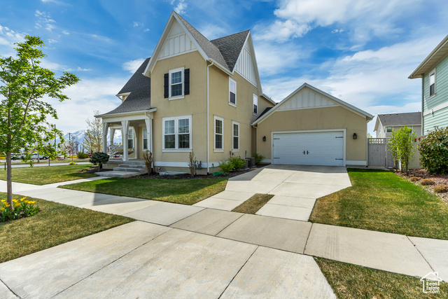 View of front facade featuring central AC, a garage, and a front lawn