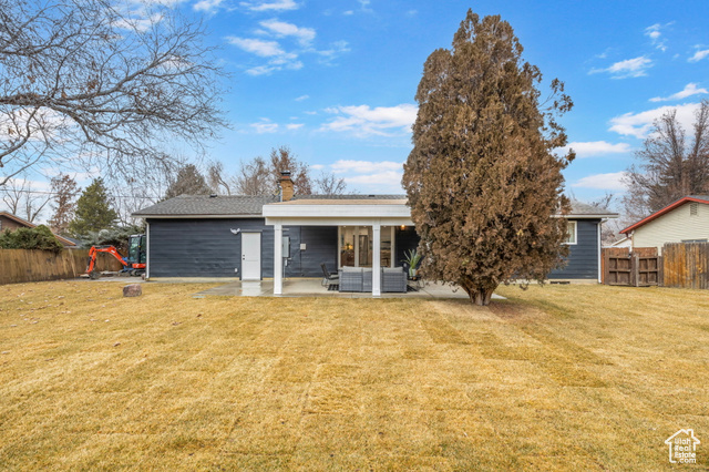 Rear view of property with a yard and a patio