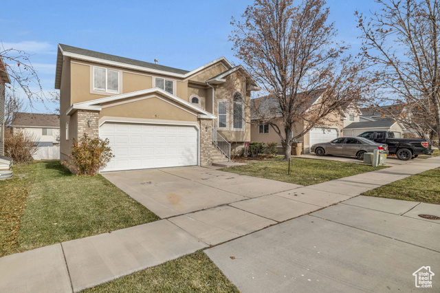 View of front of home featuring a garage and a front lawn