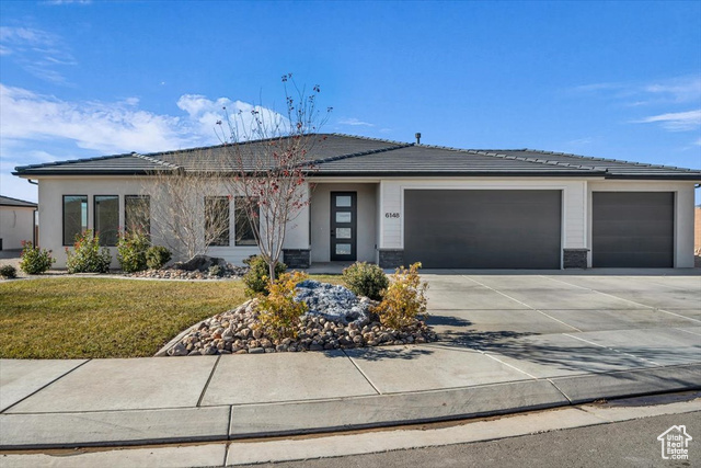 Prairie-style home featuring a front lawn and a garage