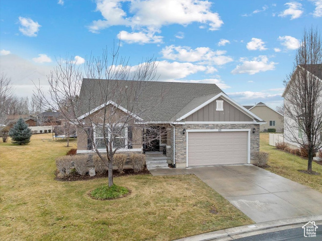 View of front of property with a front yard and a garage