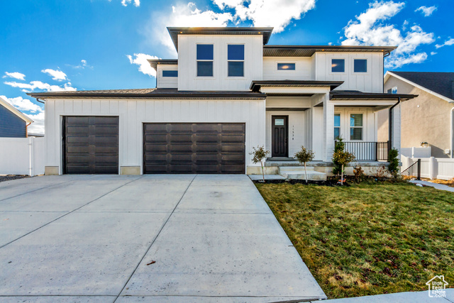 View of front of property with a front yard and a garage