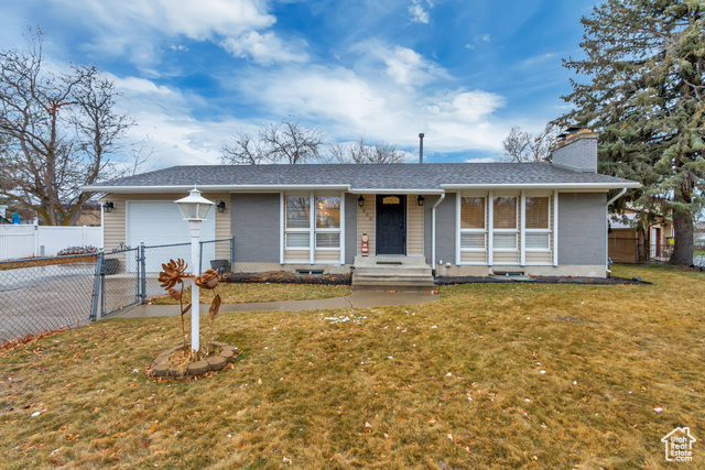 Ranch-style home with a front lawn and a garage