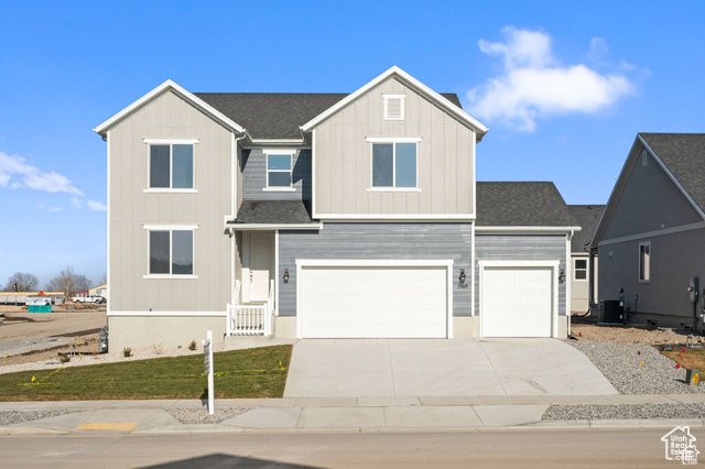 View of front facade featuring a garage and central AC