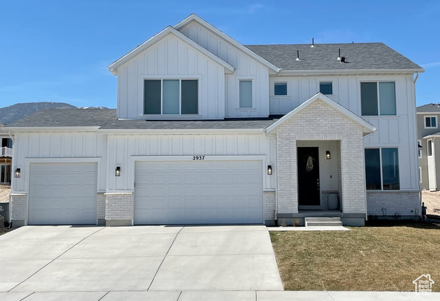 View of front of house with a mountain view and a garage