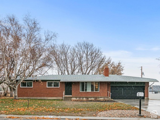 View of front of property featuring a front lawn and a garage