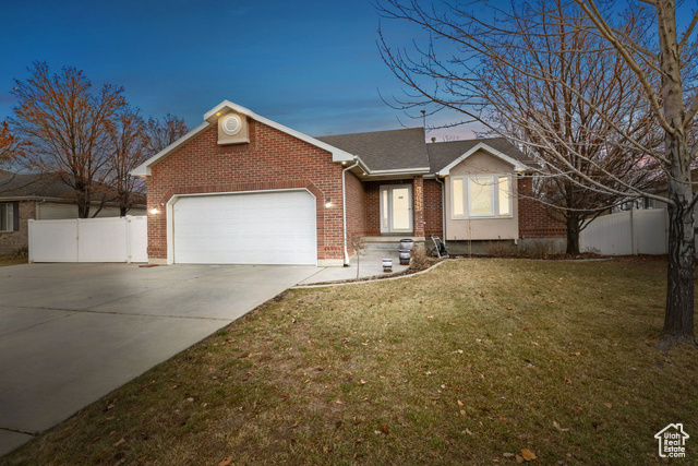 View of front of house featuring a garage and a lawn