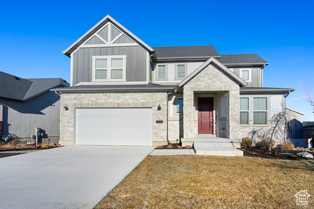 View of front of house with a garage and a front yard