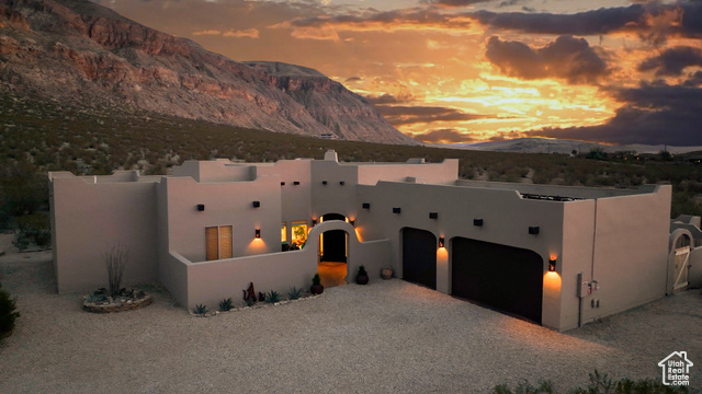 Pueblo-style house featuring a mountain view and a garage